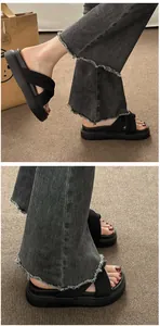 Detailed shot of women's black platform sandals with crisscross straps worn on feet.