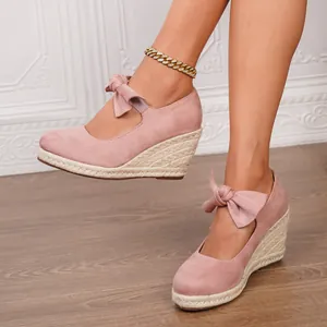 Elegantes sandalias de cuña rosa con puntera cerrada, lazo y plataforma de yute.