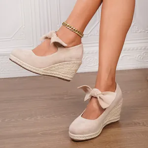 Elegantes sandalias de cuña en ante beige con lazo al tobillo y tacón de alpargata trenzada