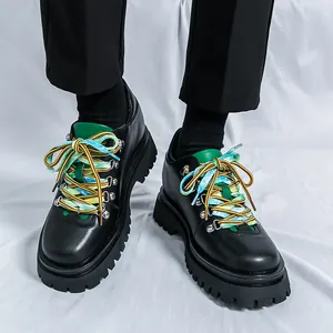 Scarpe in pelle nera da uomo con suola spessa, lacci colorati e dettaglio linguetta verde