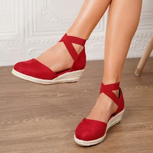 Sandalias de cuña rojas con correas elásticas en el tobillo y suelas de esparto para el verano