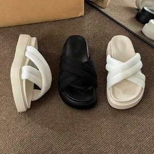 Detail shot of platform sandals with criss-cross ribbed straps in black, beige and white.
