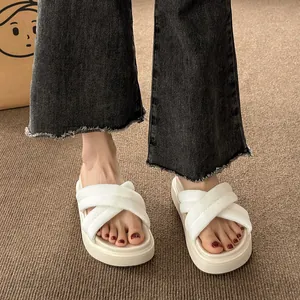 Close-up of woman wearing white platform crossover sandals on brown carpet