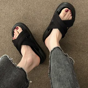 Detail view of women's black criss-cross strap sandals with comfortable thick soles