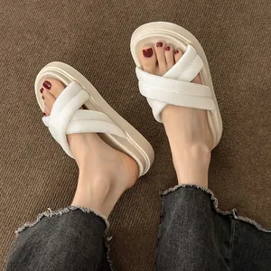 Top-down view of stylish cream platform sandals with woven cross-straps worn on feet