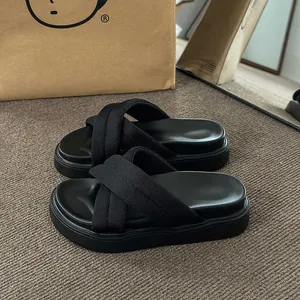 Detailed view of women's black thick-soled platform sandals with knit cross-strap