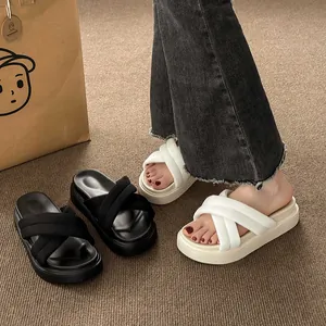 Detailed view of women's thick-soled cross-strap platform sandals in black and white colors