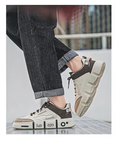 Side view of trendy cream and brown men's sneakers on foot with denim jeans