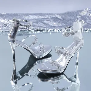 Detailed view of silver rhinestone sandals featuring star decorations and stiletto heels