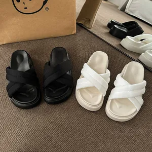 Detail view of stylish platform cross-strap slide sandals in black and off-white