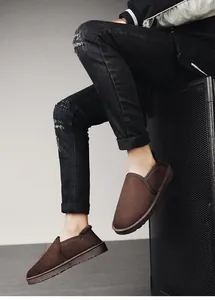 Detailed side view of dark brown suede slip-on snow boots with warm fleece lining for winter