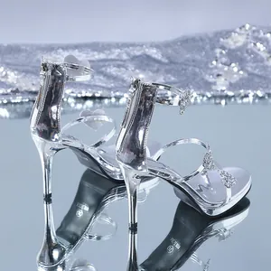 Close-up of silver high-heel sandals with sparkling rhinestone heart details