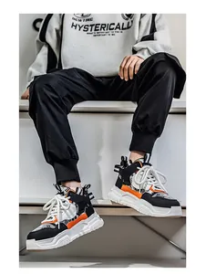 Dettaglio di sneakers alte da uomo con suola spessa e accenti arancioni sul modello