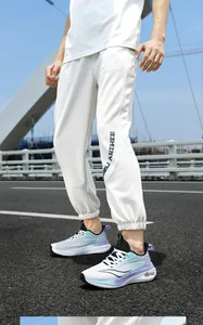 Gedetailleerd overzicht van witte fly-knit sportschoenen met blauw-paarse accenten.