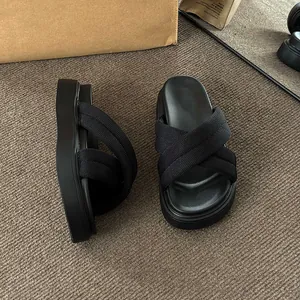 Detailed view of comfortable black platform sandals featuring cross-over knit straps