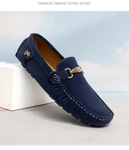 Detailed view of navy blue suede men's loafers with gold buckle and white stitching