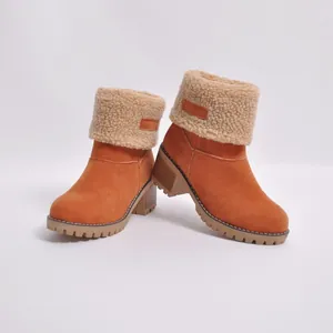 Close-up of orange suede winter boots with plush faux shearling trim and thick soles