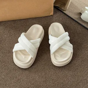 Chic cream platform sandals with cross ribbon straps on textured brown background