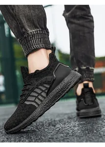 A detailed close-up showing the texture of lightweight black knit running shoes worn outdoors
