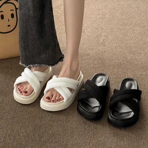 Detailed view of women's white and black platform cross-strap summer beach sandals