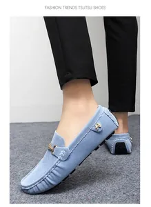 Close-up of light blue suede men's loafers with metal buckle and white stitching detail