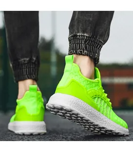 Detail shot of neon green fly-woven running shoes focusing on the textured white sole.