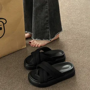 Close-up of black platform sandals featuring stylish cross-straps and a soft, comfortable thick sole.