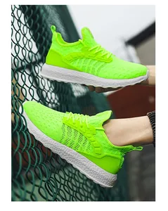 Detailed view of neon green flyknit running shoes on a textured fence backdrop