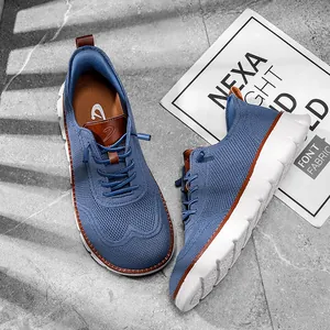 Gros plan sur des baskets d'été en tricot bleu pour hommes avec semelles blanches.