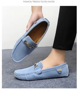 Detail of blue suede men's loafers with gold buckle and white contrast stitching