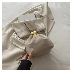 Close-up detail view of a vintage pleated suede bucket bag featuring a gold ring handle