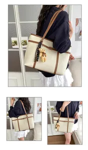 Lifestyle view of minimalist cream tote bag with bear charm and scarf detail