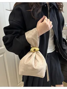 Elegant vintage beige pleated bucket bag with metallic gold handle for niche style