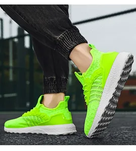 Close-up detail of lightweight neon green mesh running shoes on feet outdoors