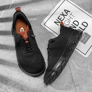 Vue détaillée de chaussures décontractées en maille fly-knit noire sur un fond en pierre grise