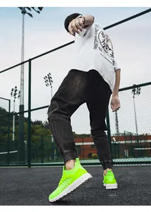 Detail view of vibrant neon green flyknit running shoes worn on an outdoor sports court