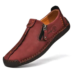 Detalle de los mocasines de cuero burdeos para hombre con costuras a mano y cremallera lateral.