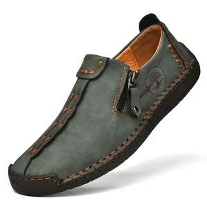 Primer plano de costuras artesanales y cremallera en mocasín de cuero para hombre.