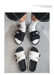Detail view of men's sports slides featuring adjustable velcro straps in black and white