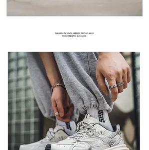 Lifestyle detail of white and silver sporty dad sneakers with grey joggers