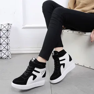 Détail de baskets compensées montantes avec bloc de couleurs noir et blanc et velcro.
