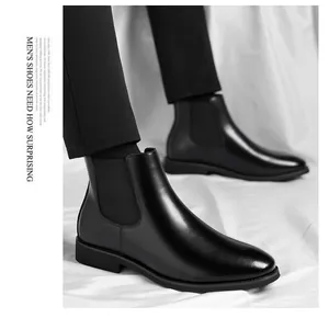 Close-up detail of premium black leather men's Chelsea boots on white fabric background