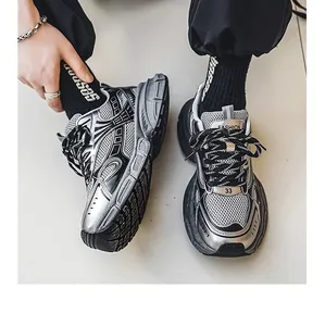Close-up of stylish silver and black men's dad sneakers with layered mesh design.