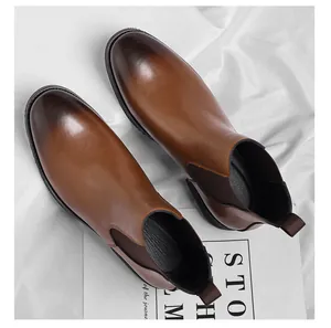 Close-up top-down view of vintage brown leather Chelsea boots for men on white cloth