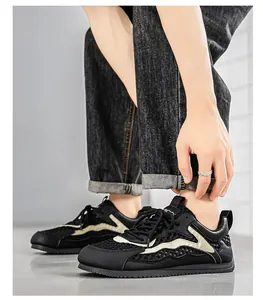 Vista dettagliata di sneakers in mesh nero traspirante da uomo con motivo a onde dorate