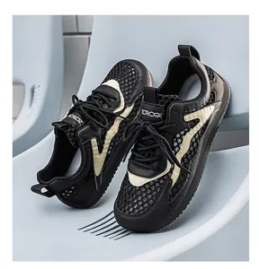 Macro dettaglio di sneakers in mesh nero e beige con texture traspirante e lacci.