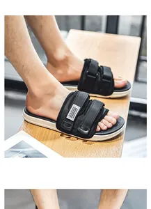Close-up of black men's sport slides with adjustable velcro straps on a wooden surface
