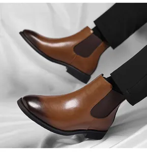 Close-up detail of stylish tan leather Chelsea boots featuring a burnished gradient toe
