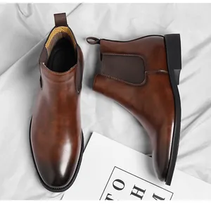 Top-down view of brown vintage Chelsea boots on white satin background
