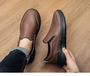 Nahaufnahme von braunen Slipper-Schuhen aus genarbtem Leder für Herren auf Holzboden